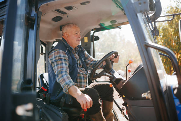 istock Mastering the Fields Senior Farmer Drives Tractor Through Farmland 2155775659