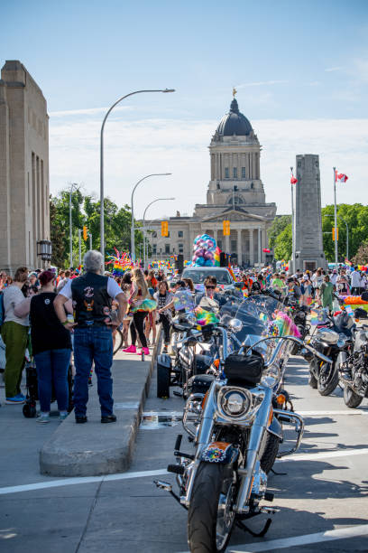 Winnipeg Manitoba Canada - July 2 2024 /A sea of people participates in the Winnipeg Pride Parade,  with the Manitoba Legislature Building standing proudly in the background.