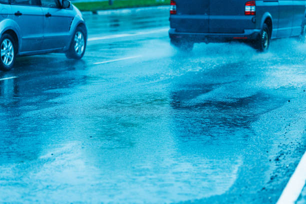istock Splashes of water from passing car. Wet road. 2155779496