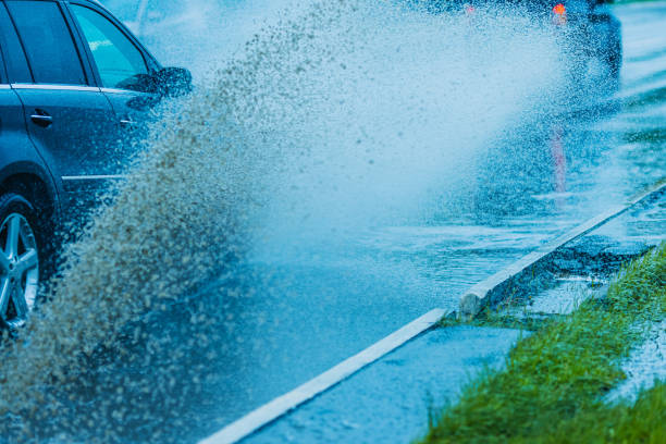 istock Splashes of water from passing car. Wet road. 2155780377