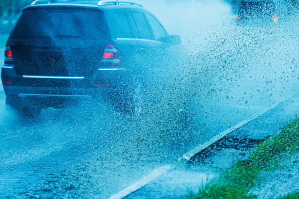istock Splashes of water from passing car. Wet road. 2155780472