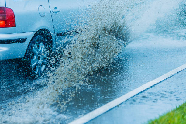 istock Splashes of water from passing car. Wet road. 2155781201