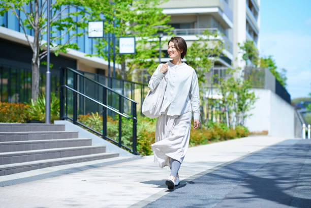a woman walking down the street with shopping bags - frauenthemen stock-fotos und bilder