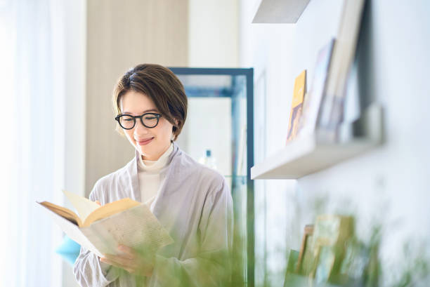 woman reading in the room - 読む ストックフォトと画像