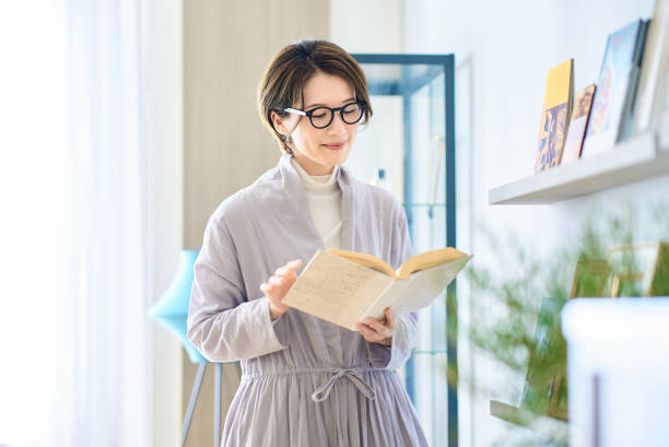Middle-aged woman reading in her room