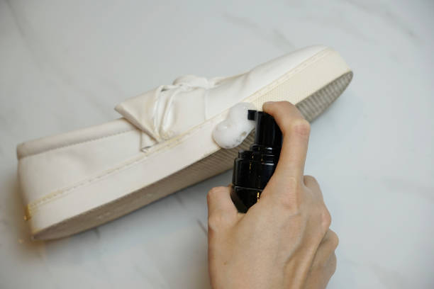 istock Cropped hand spraying cleaning foam on a sneaker base 2155790013
