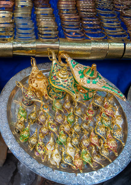 Jemaa el-Fnaa, Marrakech, Morocco - March 18, 2024: A collection of ornate Aladdin lamp-shaped ornaments displayed on a large silver platter.