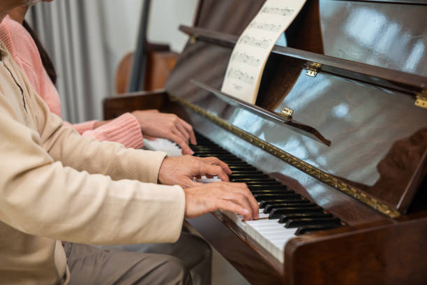 istock Young woman teaching piano for senior man teaching 2155795528