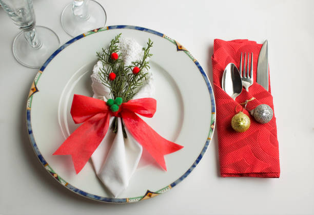 Close-up taken of designed elegance christmas dining table with christmas ornaments and fancy folded fabric napkin.