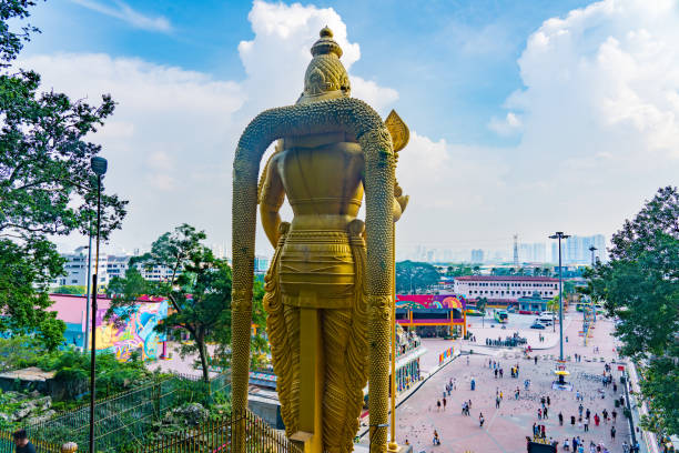 Kuala Lumpur, Malaysia - May 15, 2024 : Arulmigu Murugan Statue in Batu Caves with Kuala Lumpur in Background
