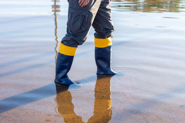istock Man in galoshes walking through flooded area 2155803015