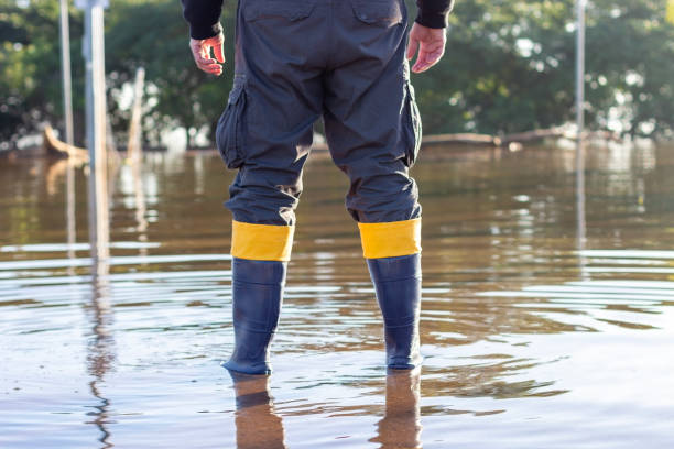 istock Rescuer standing in flooded area wearing rubber boots 2155803038