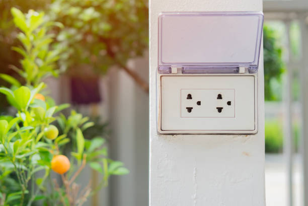 istock White plug on white wall with a garden in the background, plug socket, electric, plug outlet 2155803477