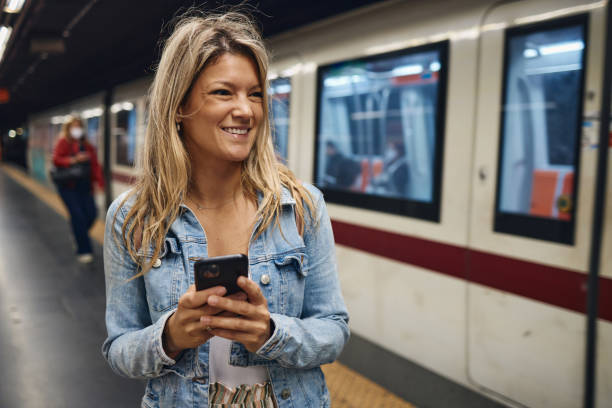 istock Young female tourist using a phone while waiting for a train 2155805586