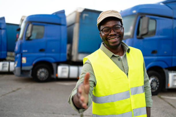 istock Truck driver in reflective vest welcoming new drivers. 2155805923