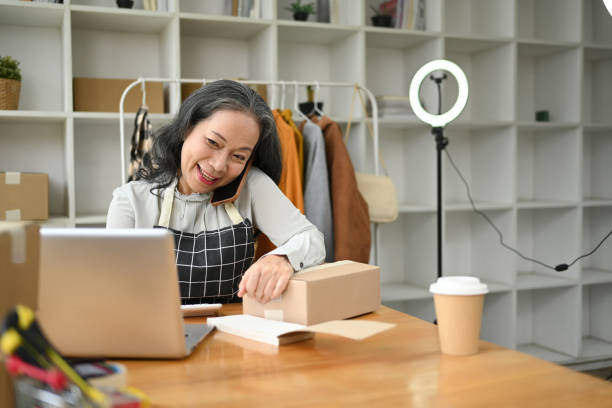 istock Mature small business owner talking on mobile phone, receiving purchase order 2155806879