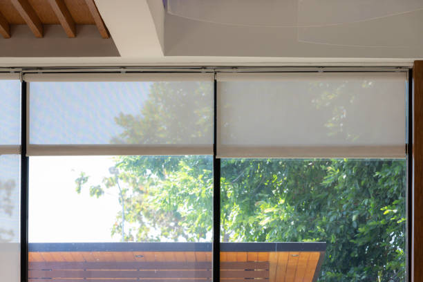 A large window with white blinds, allowing sunlight to stream in