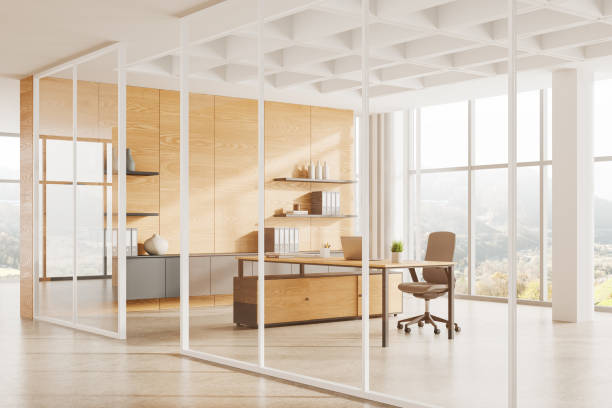 istock Stylish office interior with work table and laptop, shelf and panoramic window 2155808752