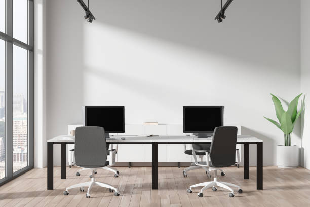 istock Modern office interior with computers, chairs, plant, and large windows on a cityscape background, concept of a corporate business space. 3D Rendering 2155809039