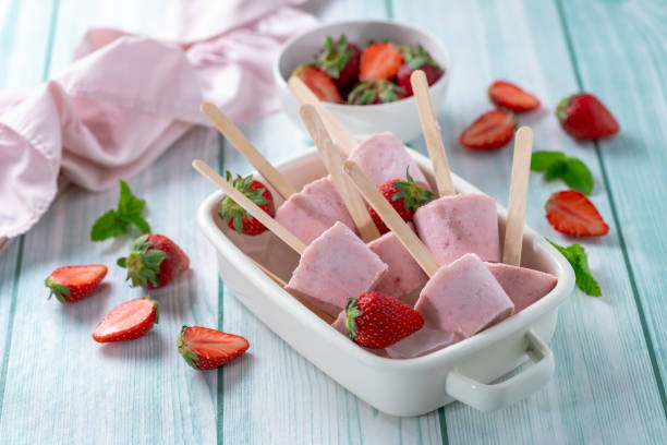 istock Strawberry popsicles with mint on a stick on a blue wooden table. 2155809294
