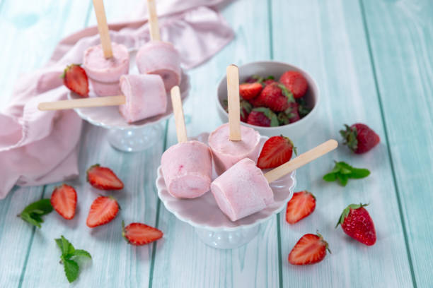 istock Strawberry popsicles with mint on a stick on a blue wooden table. 2155809301