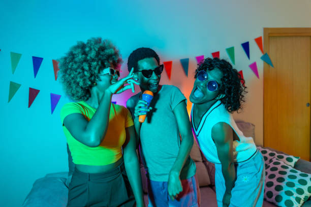 istock Multiracial friends partying at night singing karaoke at home 2155809306