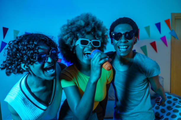 istock Multiracial friends singing karaoke partying at home 2155809409