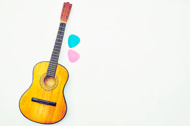 istock Music. Acoustic yellow guitar with picks mediators on white 2155810106