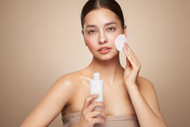 istock Young woman cleansing face with cosmetic milk 2155812355