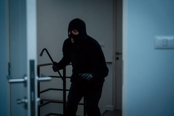 istock Thief in uniform black jacket various action housebreak. The Robber terrorism criminal escapes with balaclava and crowbar entering a house for stealing Housebreak at night 2155812434