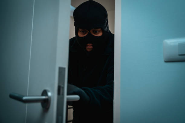 istock Thief in uniform black jacket various action housebreak. The Robber terrorism criminal escapes with balaclava and crowbar entering a house for stealing Housebreak at night 2155815458