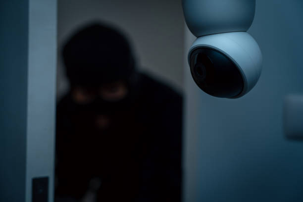 istock Security camera.Thief in uniform black jacket various action housebreak. The Robber terrorism criminal escapes with balaclava and crowbar entering a house for stealing Housebreak at night 2155816171