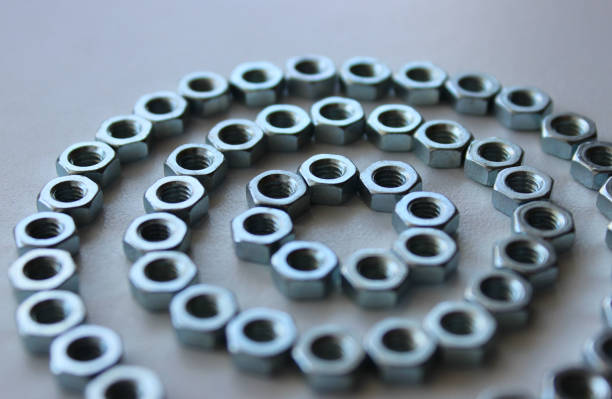 Iron Fastener Nuts Laid Out In Three Circles Shape On White Surface