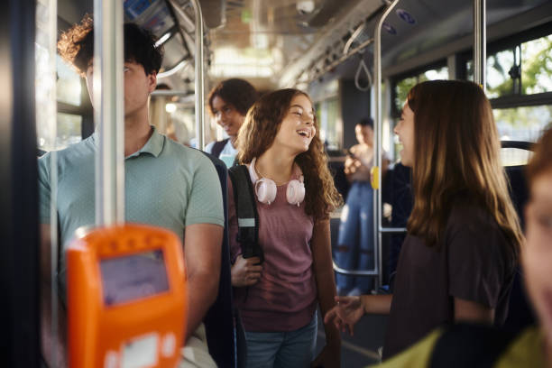 istock Happy students talking while traveling to school in a bus. 2155819731