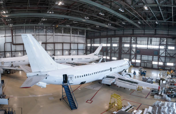 istock White passenger airplanes in the aviation hangar. Aircrafts under maintenance. Checking mechanical systems for flight operations 2155820001