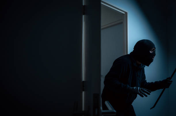 istock Thief in uniform black jacket various action housebreak. The Robber terrorism criminal escapes with balaclava and crowbar entering a house for stealing Housebreak at night 2155820774