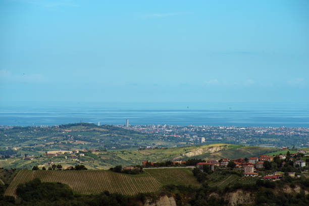 A serene autumn morning in Val d'Orcia, Tuscany, featuring the historic Rocca di Tentennano and the village of Castiglione d’Orcia, bathed in soft golden light over rolling hills and cultivated plowed fields.