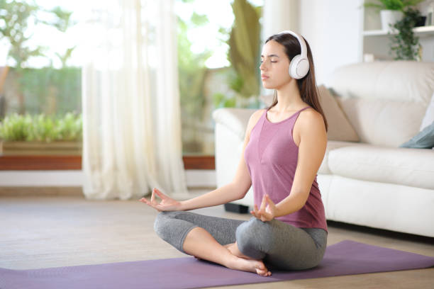 istock Yogi doing guided yoga exercise wearing headphone 2155822524