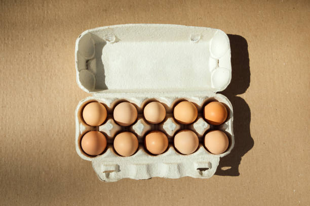 istock Chicken eggs of different brown and beige shades on a brown cardboard background in eggs container 2155823402