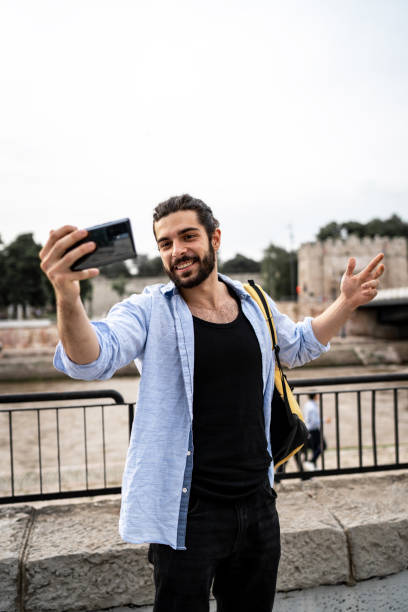 istock Young smiling man using smartphone on the street 2155824445