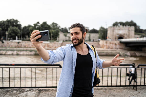 istock Young smiling man using smartphone on the street 2155824649