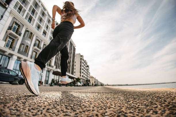 Low-angle view of a runner preparing for a half marathon in a city by the sea. Thessaloniki half marathon. Modern life and nature. Sports shoes in focus