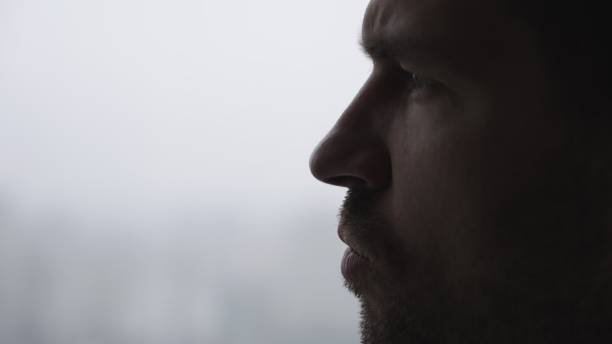 istock Young bearded man is thoughtful posing near the window. Slow motion 2155826740