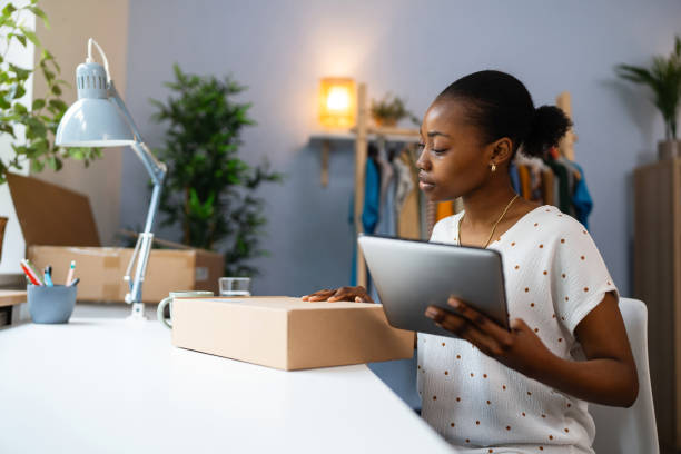 istock Female small business owner Black ethnicity preparing package for delivery 2155826882