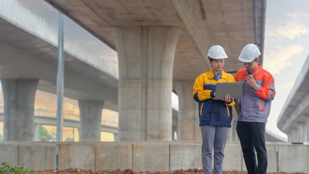 istock Asian male and female engineers Inspecting construction work radio command concrete road bridge highway 2155826890