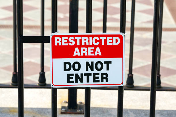 Restricted area sign on a fence with Do Not Enter message. No people.