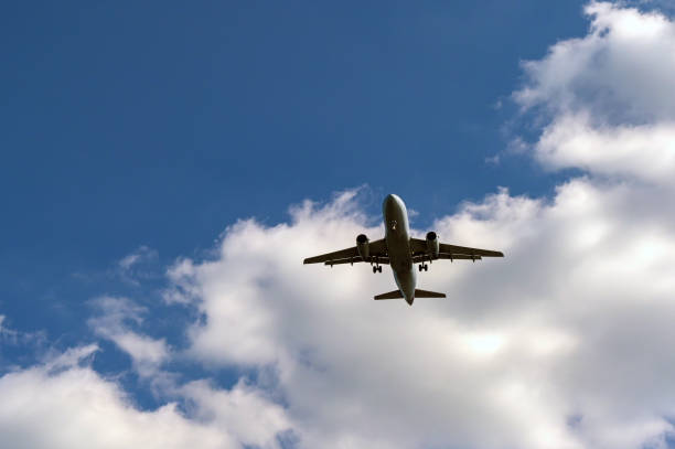 istock Unmarked holiday jet against a blue sky with white clouds 2155830024