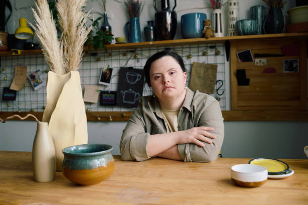 istock Young Woman With Down Syndrome Sitting At Table 2155833082