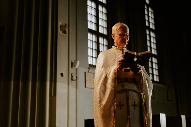 istock Senior Priest Reading Bible 2155837381