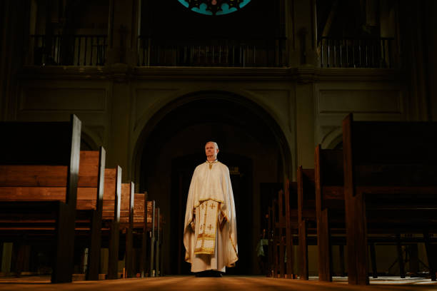 istock Senior Priest Standing Indoors 2155837656